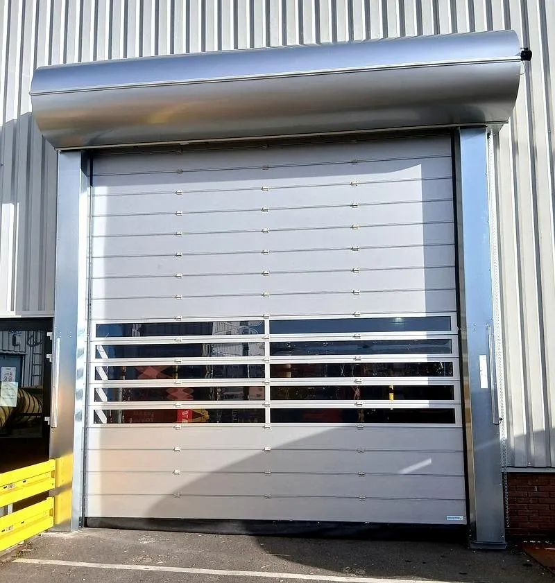 Industriële snelroldeur bij laadkade van magazijn tijdens winter om warmteverlies en energiekosten te beperken